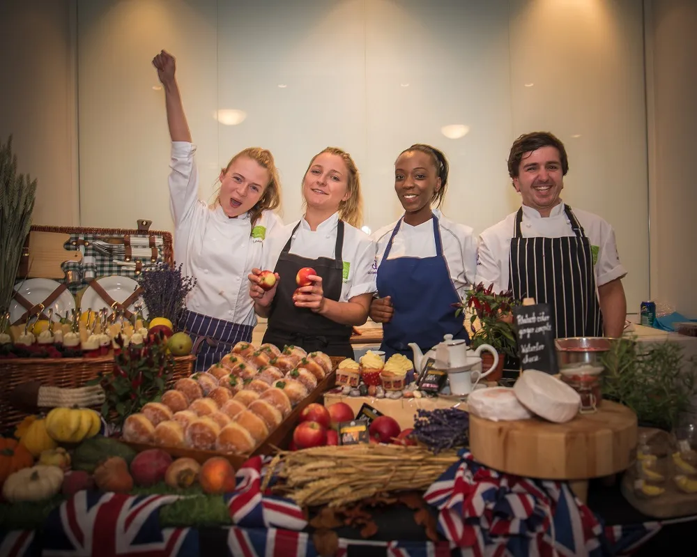 team behind a table of sweets and fruits