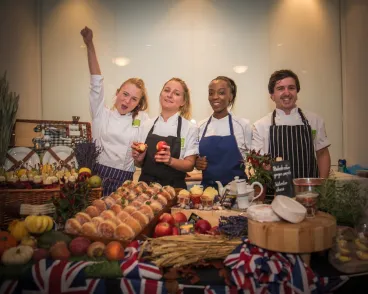 team behind a table of sweets and fruits
