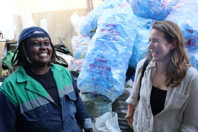 women smiling in front of plastic bags